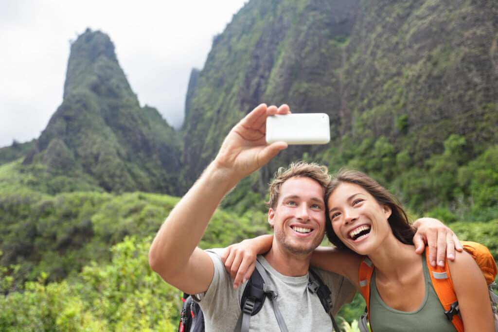 Maui Iao Valley State Park Tours A couple taking a selfie with the beautiful Iao Valley Maui, Hawaii as a backdrop